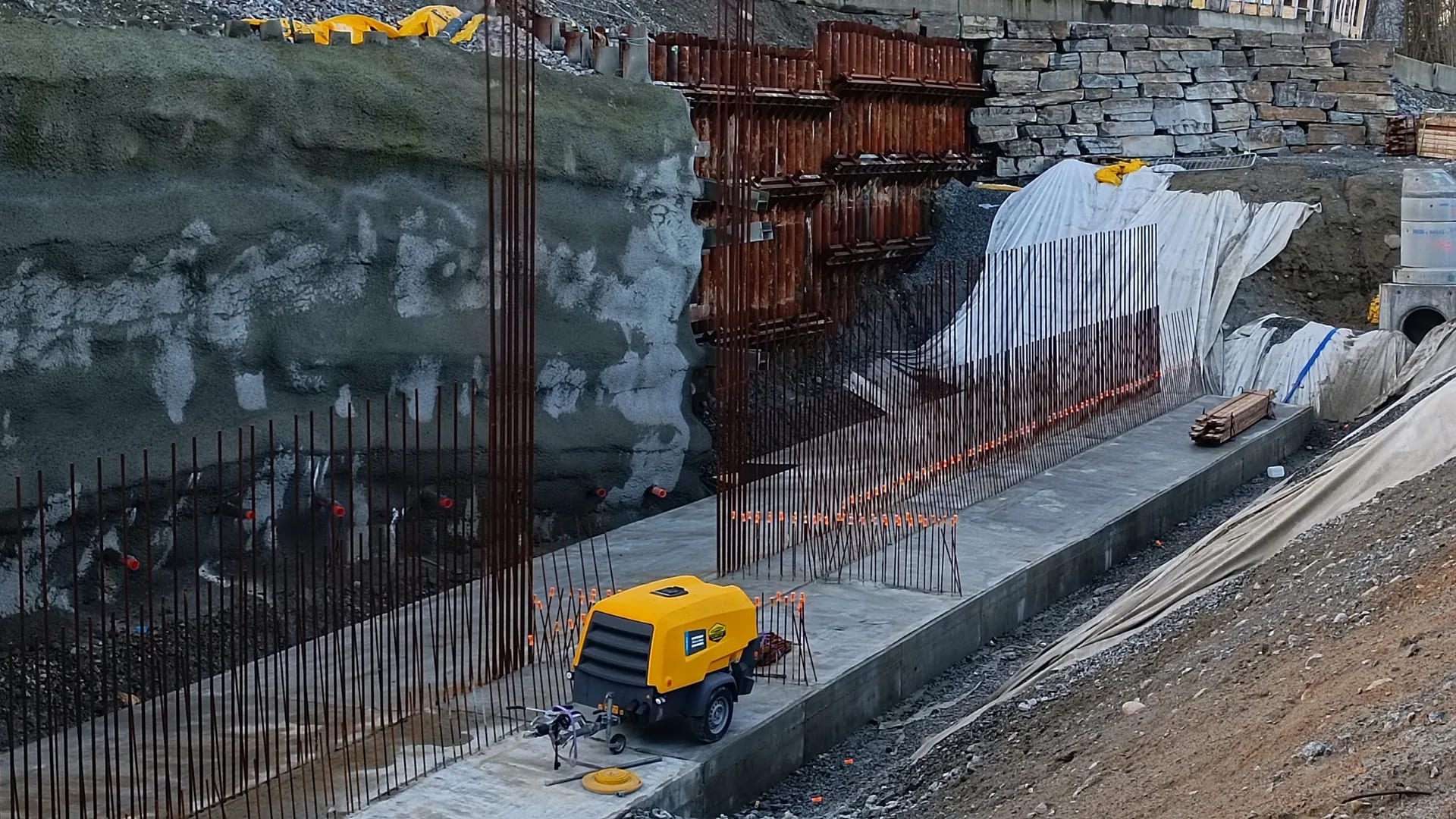 Freshly cast strip foundation with starter bars along the excavation for the bus corridor.