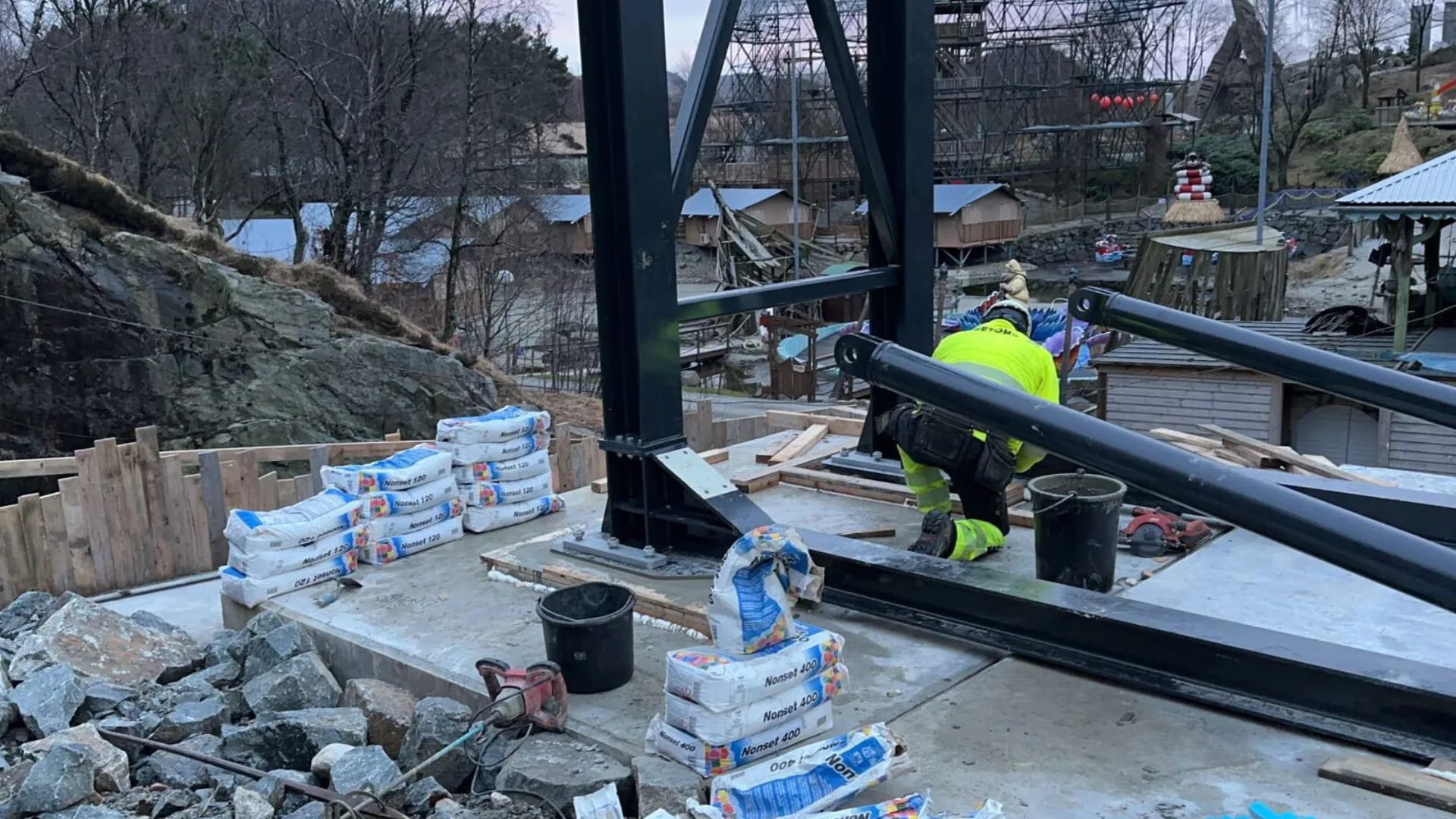 Grouting the steel columns on their footing, the park just behind.