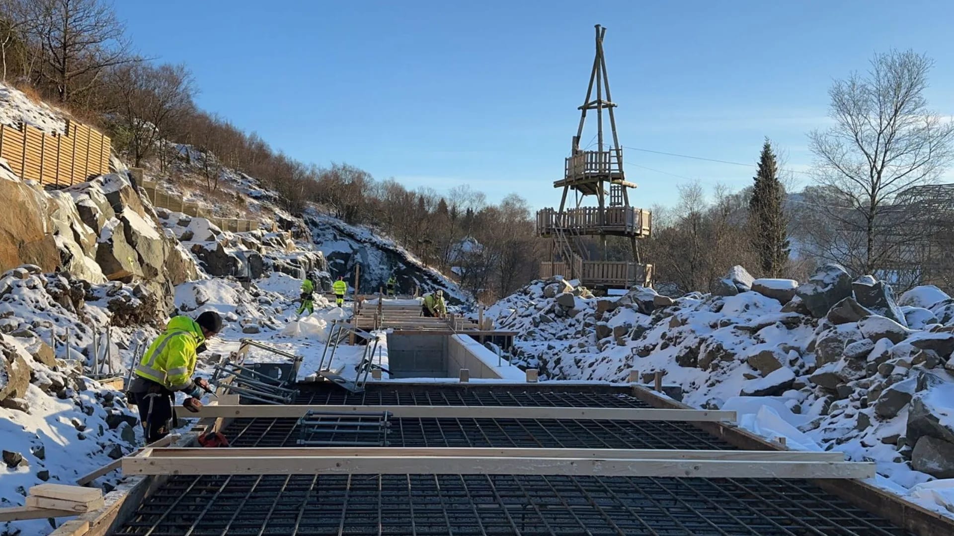 Winter work: reinforcing the base slabs between snow-covered rocks.