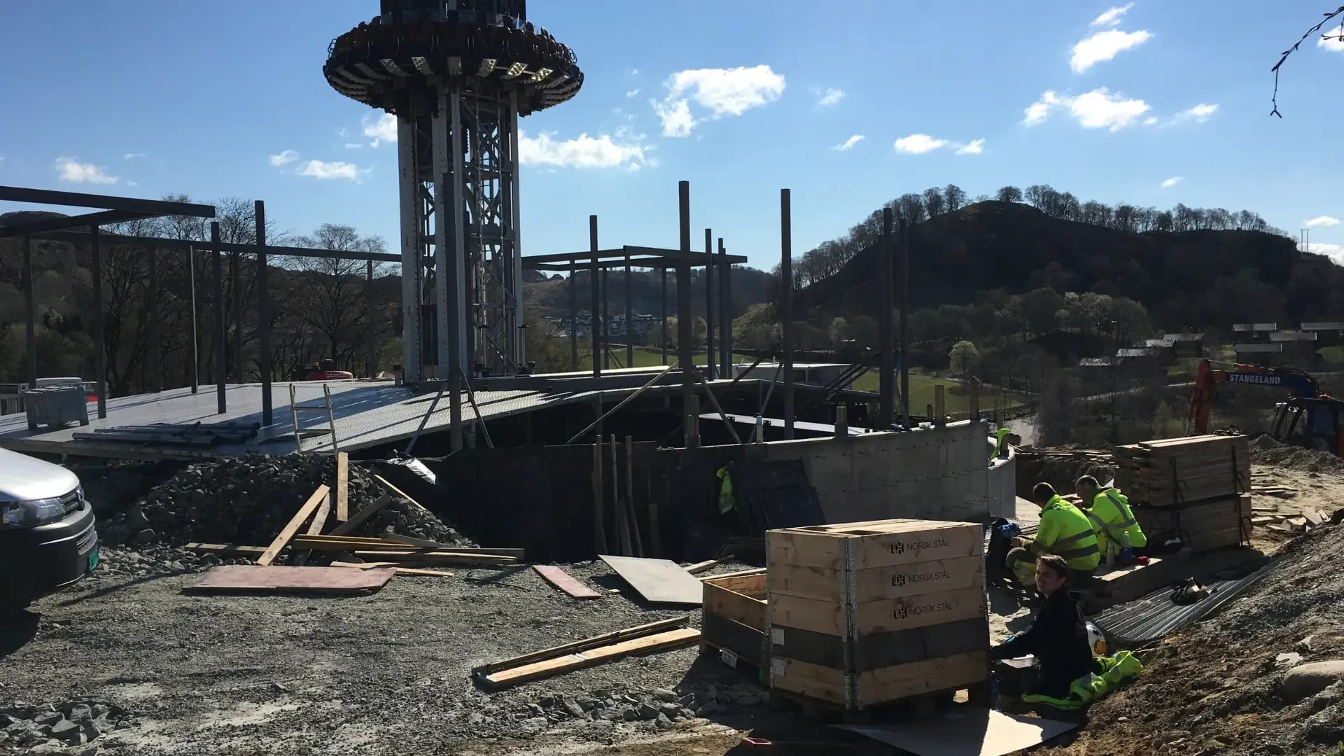Foundations and walls rising between the steel columns.
