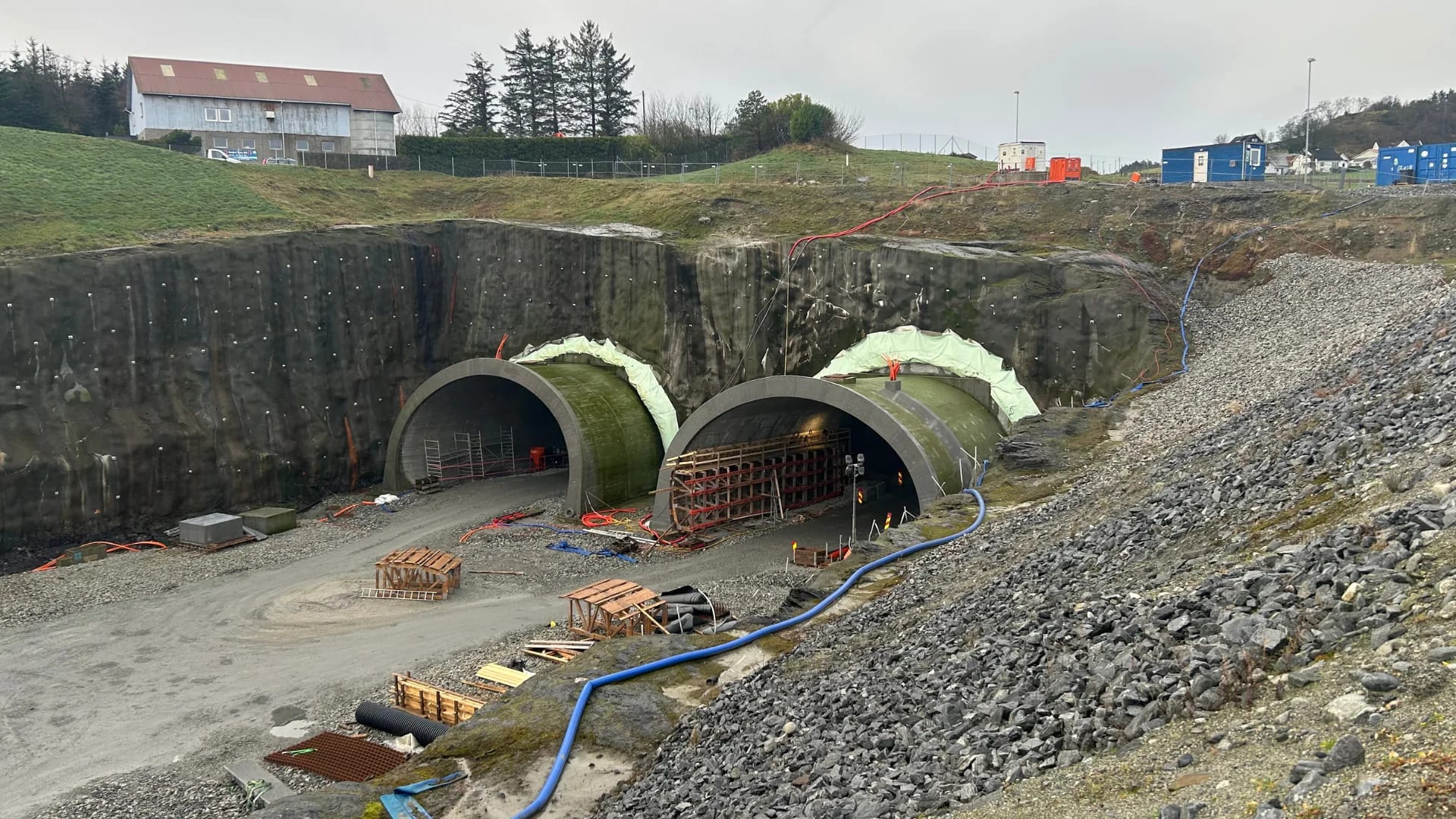 The twin tunnel portals cast and being covered in the rock cutting.